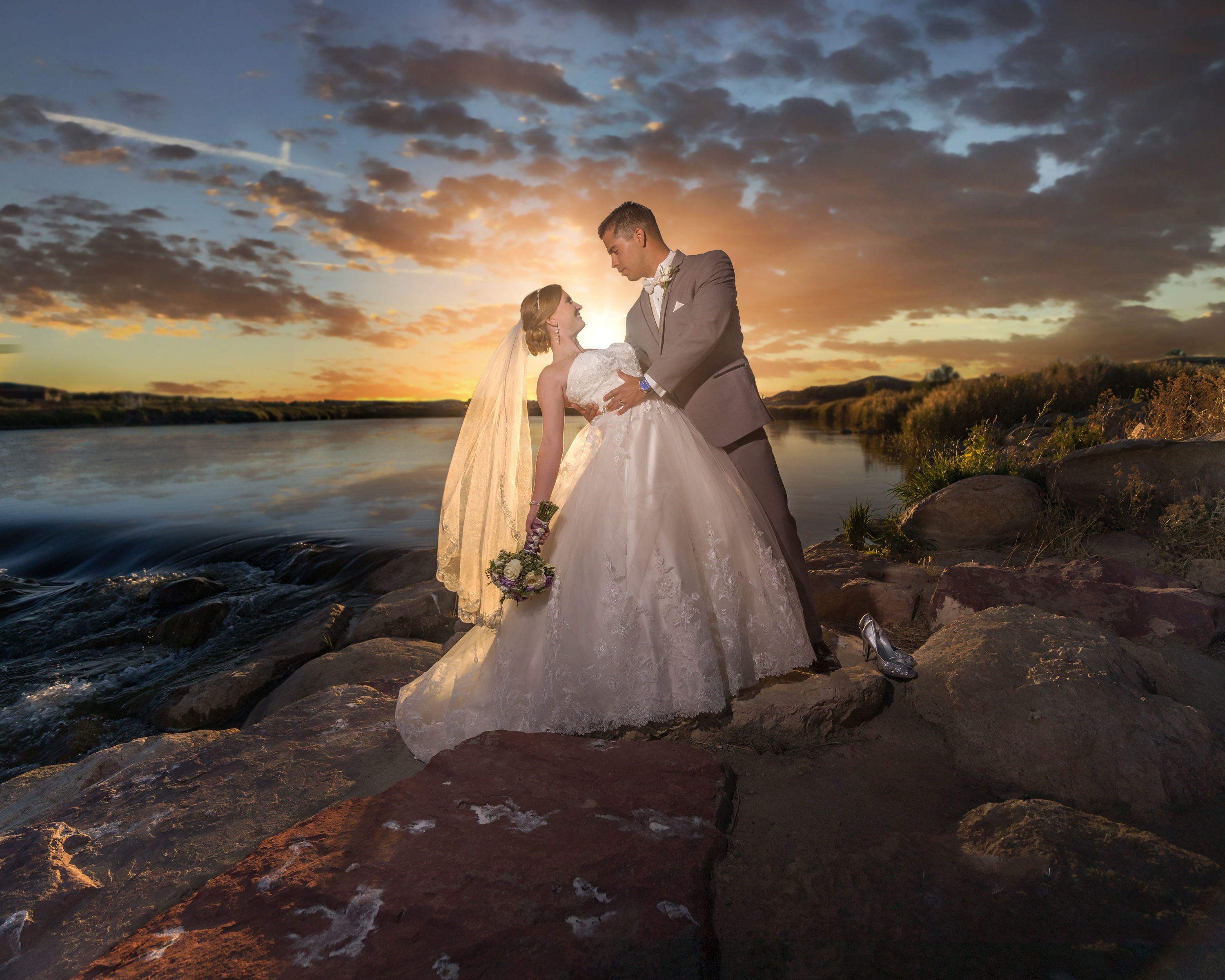 Wedding portrait at sunset beside the river by Ken Stoecklin